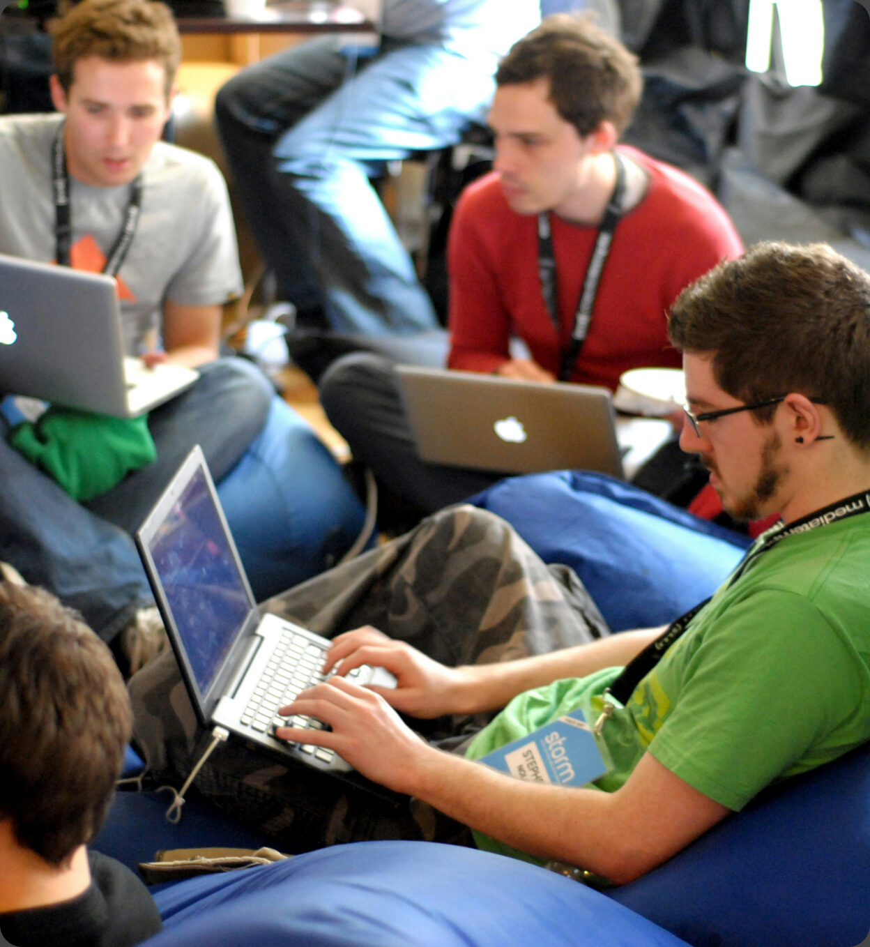Participants working side by side on laptops during an in-person hackathon